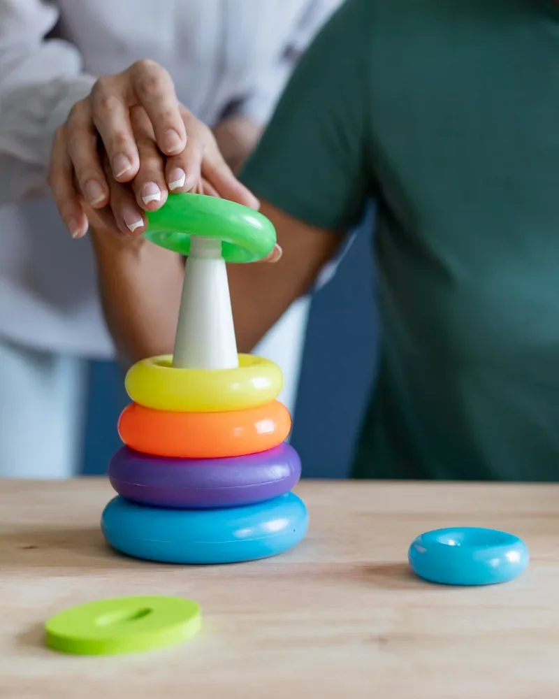 Close view of a therapist guiding a patient's hands through a coordination task