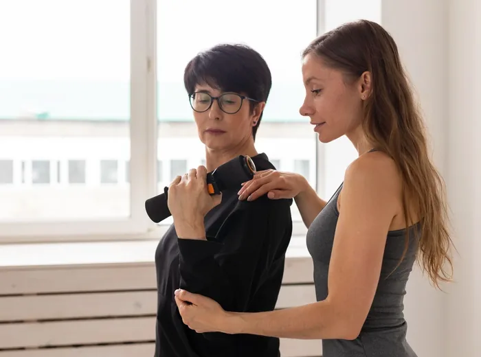 Therapist supporting a patient through a guided standing exercise